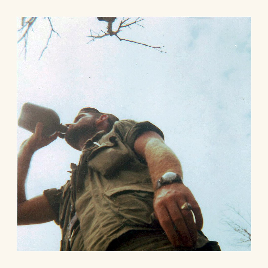 American soldier in Vietnam drinking from a flask 
